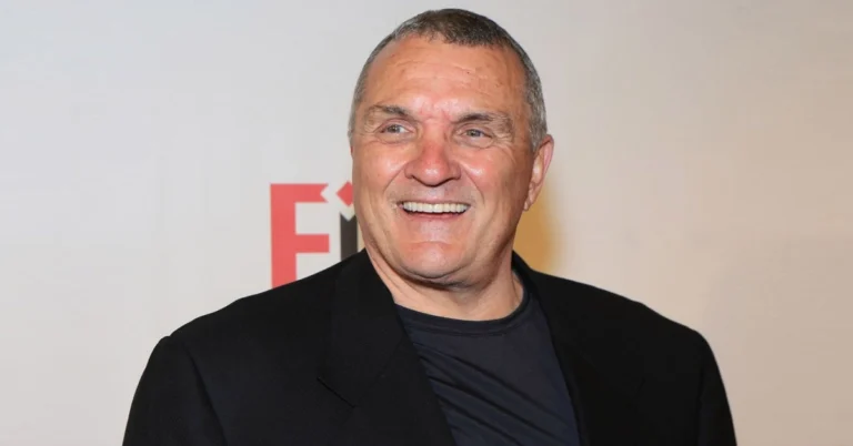 Inspirational portrait of Rudy Ruettiger smiling confidently, symbolizing determination and success, highlighting Rudy Ruettiger Net Worth journey.