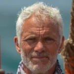 Jeremy Wade standing outdoors by the water, looking determined, embodying the adventurous spirit of the River Monsters host and extreme angler.
