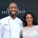 Larry Fitzgerald Wife, Melissa Blakesley, posing with Larry at a public event, both smiling and dressed in elegant attire.