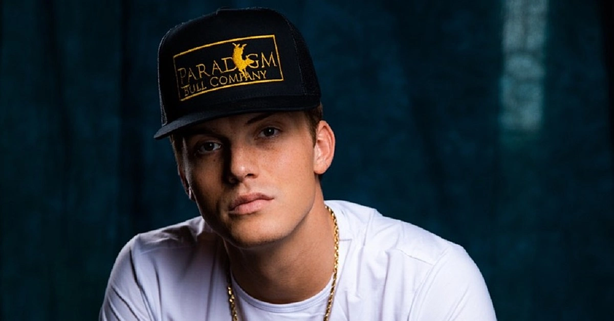 Parker McCollum wearing a black Paradigm Bull Company hat and white t-shirt with gold chain necklace - country music star with $4-7 million net worth in 2025