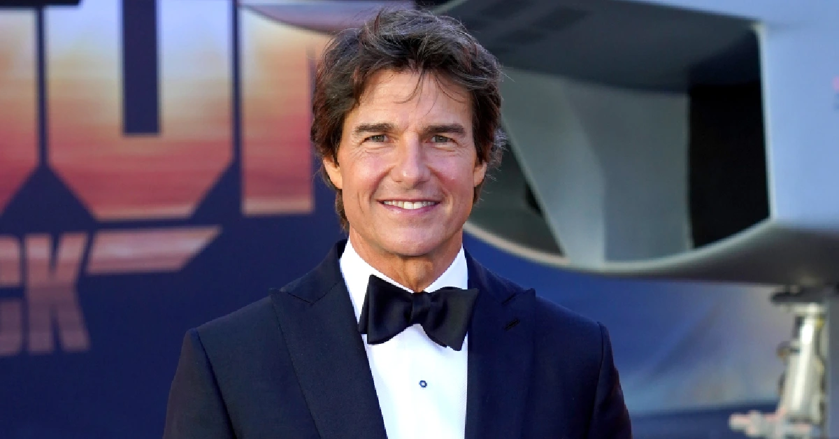 Tom Cruise smiling in a navy tuxedo with bow tie at a Top Gun premiere event, representing his $600 million net worth in 2025