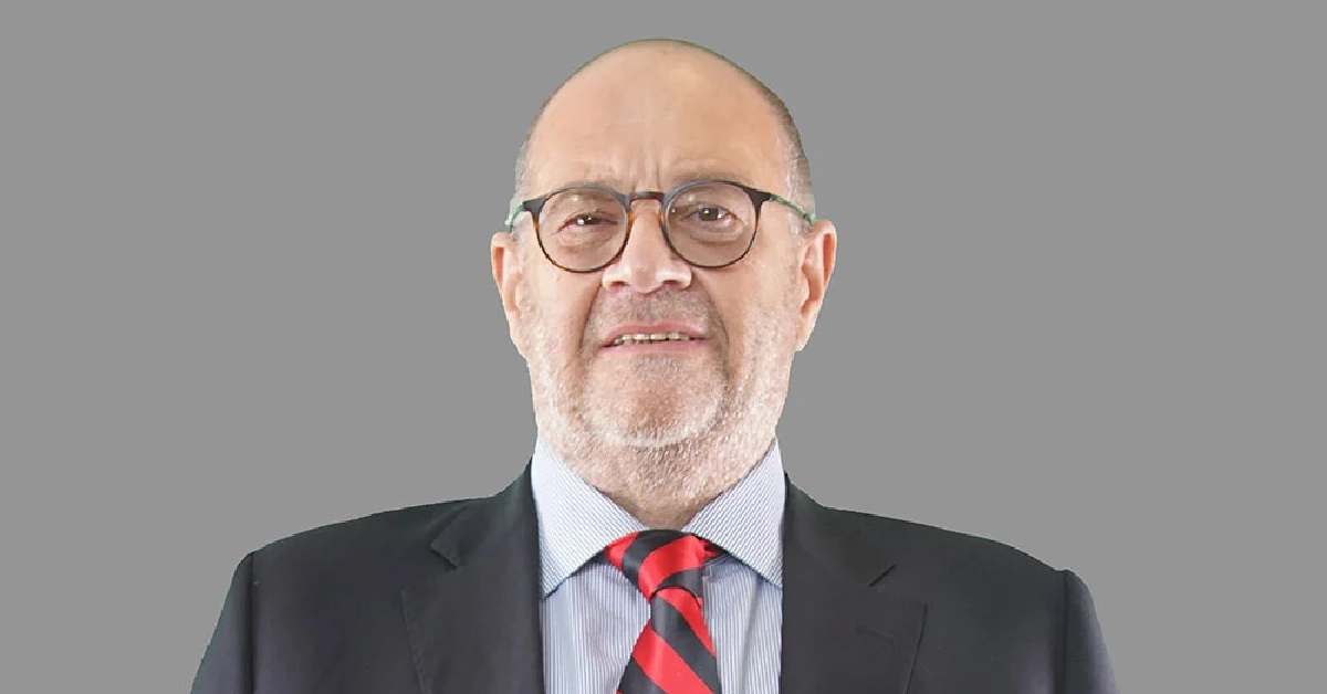 Mehmet Behçet Piker in business attire with glasses and red striped tie, former Sabancı Holding executive with estimated net worth between $150-200 million